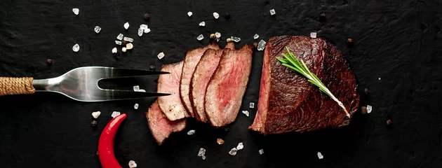  beef steak on a cutting board. on a dark concrete background © александр таланцев