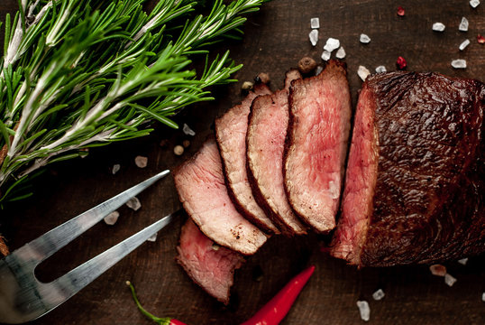 beef steak on a cutting board. on a dark concrete background