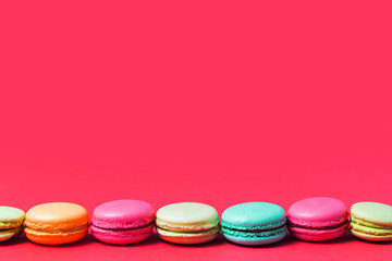 Bright pink background for text with colorful French macaroons