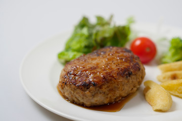 Hamburger steak and vegetables on white background