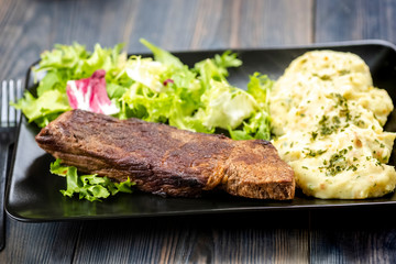 Beef steak with mashed potatoes and rocket salad