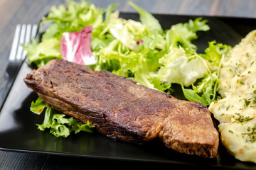 Beef steak with mashed potatoes and rocket salad