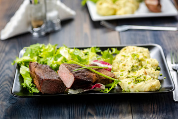 Beef steak with mashed potatoes and rocket salad