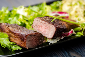 Beef steak with mashed potatoes and rocket salad