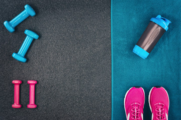 Fitness or bodybuilding concept background. Product photograph of old iron dumbbells on black grey, conrete floor in the gym. Photograph taken from above, top view with lots of copy space