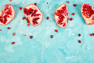Half pomegranate fruit on blue background. Fresh red ripe