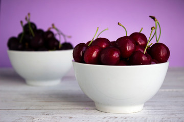 Ripe cherry berries in two white plates, fruit, background