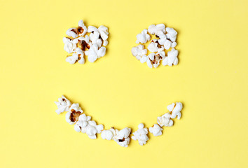popcorn laid out in the form of happy smilies on a yellow background close-up