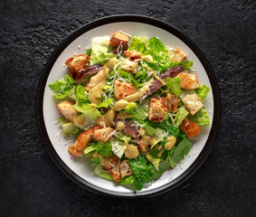 Caesar salad with chicken, anchous fish, croutons, parmesan cheese and greens. healthy food