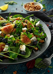 Figs salad with blueberries, walnuts, feta cheese and green vegetables. healthy food