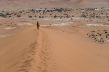 Fototapeta na wymiar girl walking the dunes in namib desert deadvlei namib desert namibia