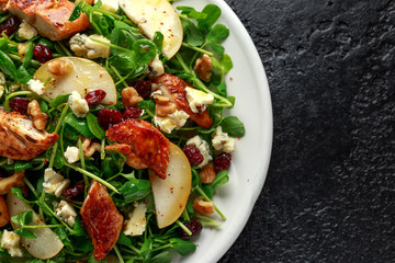 Pear, chicken salad with blue cheese, cranberry and walnuts. concept healthy food. black background