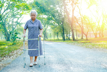 Asian senior or elderly old lady woman patient walk with walker in park : healthy strong medical concept 