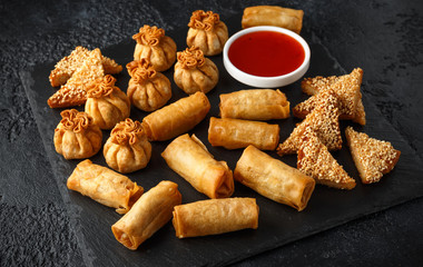 Crispy Chicken wontons, vegetable spring rolls and prawn toasts with sweet chilli sauce. chinese selection. fast food.