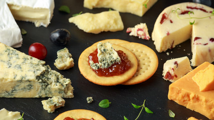Cheese platter served with grapes, ale chutney, honey, crackers on stone board. Brie, cheddar, red leicester, wensleydale cranberries, blue stilton.