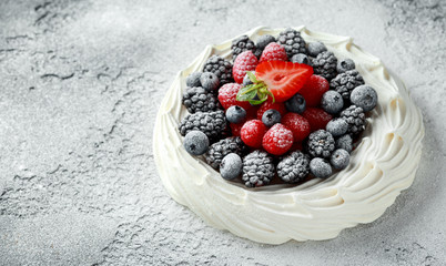 Berry Pavlova cake with fresh blueberries, strawberries and raspberries