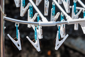White plastic clothespins selective focus in day time.