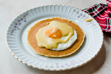 Salted Pancake with Hollandaise Suace, Eggs and Crispy Bacon for Breakfast. Salty Organic Fast Food.