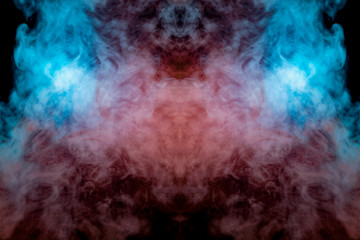 Mystical pattern of green, blue and pink colored smoke in the shape of a ghost's face with big eyes and an open mouth creating a feeling of fear on a black isolated background from a horror movie.