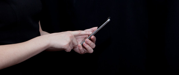 Hand holding and Touching a Smartphone isolated on black background
