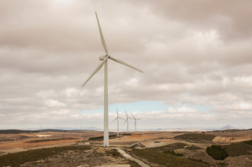 wind turbines in the field against blue cloudy sky, electric generators in countryside