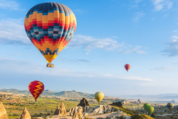 Naklejka premium Hot air balloon flying over red poppies field Cappadocia region, Turkey