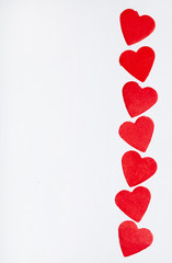 Vertical row of red toy heart on a white background