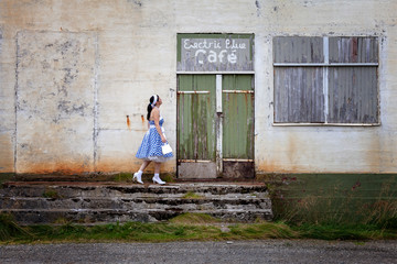 Junge Frau auf einer Zeitreise vor einer alten Location