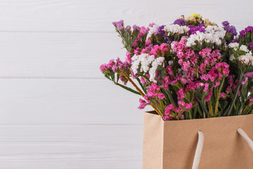 Multicolored blooming lilac flowers. Close up. White wooden background.