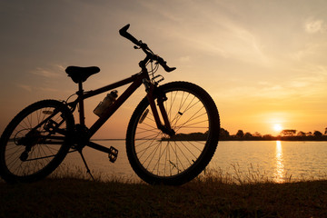 Naklejka na ściany i meble Silhouette bicycle with sunset or sunrise background