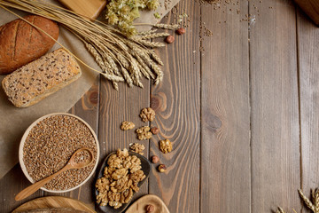 Whole grain, whole loaf and sliced pieces of multigrain bread contains whole grains (poppy, millet, flaxseed, pumpkin seeds, and sunflower seeds) isolated on dark wooden table with a copyspace.