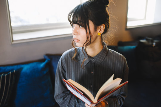 ソファーで本を読む女性