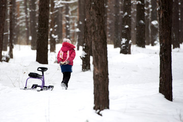 Fototapeta na wymiar Little girl alone in the winter forest