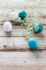 Delicate spring flowers with Easter bright eggs on a wooden tabletop. Empty space for text