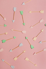 Paper Cupid arrow symbols on pink background. Flat lay, top view Valentines Day background love concept.