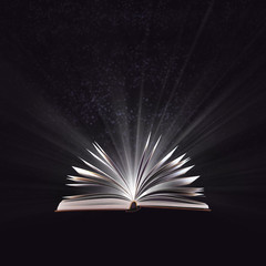Open magic book, bewitched book glows in the darkness, magic light. Education. Dreamy image of a fairytale