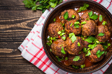 Meatballs in tomato sauce on wooden table top view. 