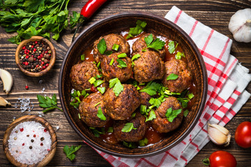 Meatballs in tomato sauce on wooden table top view. 