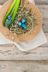 Nest in a wicker hat and painted spotted Easter eggs with hyacinth flower. Space for text