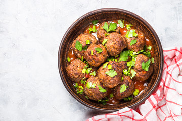 Meatballs in tomato sauce on light stone table top view. 