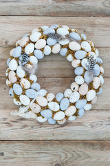 Delicate Easter wreath on the door of quail eggs on a wooden background. Text space