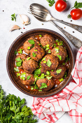 Meatballs in tomato sauce on light stone table top view. 
