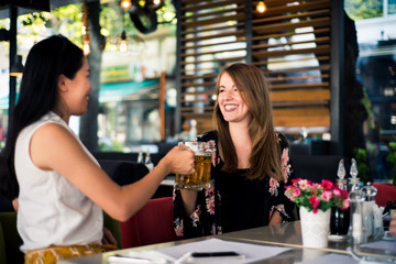 Female friends having a beer in a bar