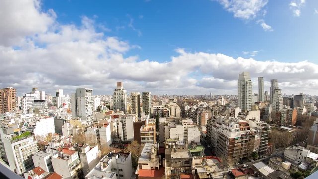 Time-lapse view on the skyline of the city from a balcony of a high rise apartment as Sun breaks through between fast move clouds in Buenos Aires.

