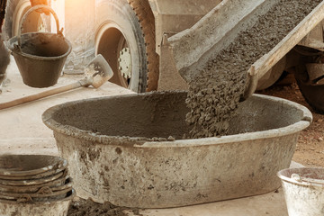 concrete mixer truck pouring concrete into large basin in construction site