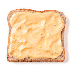Bread slice with mustard sauce isolated on white, clipping path. Slice of multigrain bread square form plaster mustard sauce for toast. Image of one slice wholegrain bread, top view or flat lay.