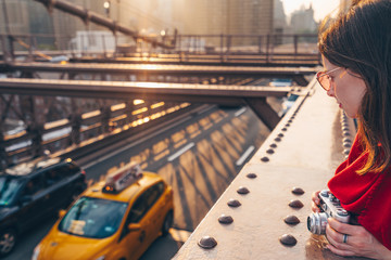 Attractive girl with a camera on Brooklyn Bridge