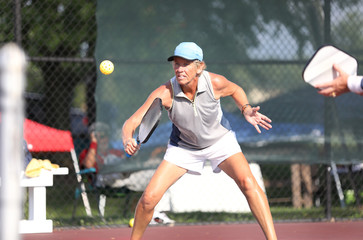 A woman competes in a pickleball match