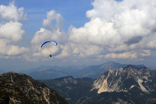 Paraglider over the tops of the mountains in summer sunny day.