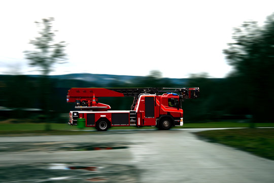 Firefighter truck driving fast on a wet road.